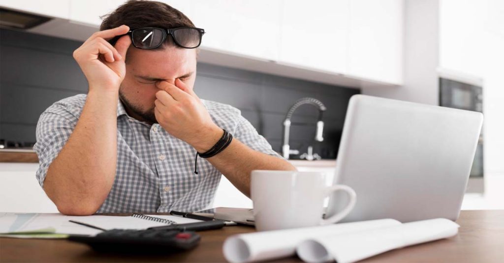 Person using laptop with correct lighting and posture to reduce eye strain.