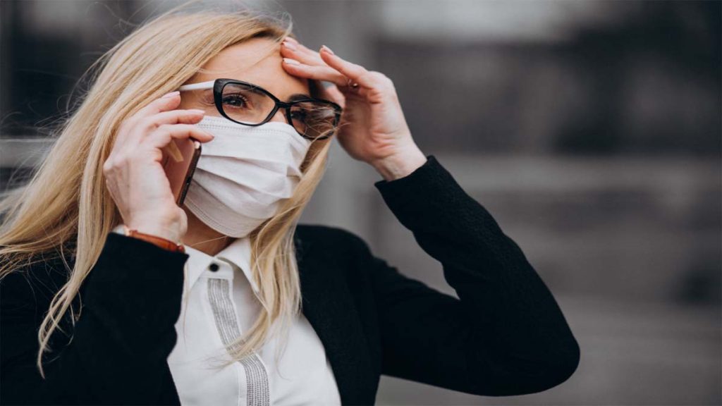 Woman with irritated red eyes caused by air pollution and dust